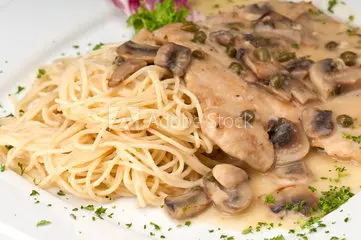 A plate with chicken breasts, mushrooms and spaghetti.