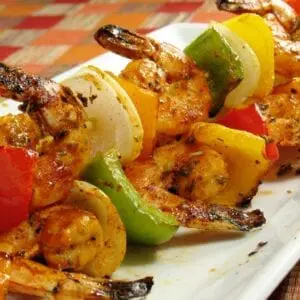 Shrimp skewers on a white plate.