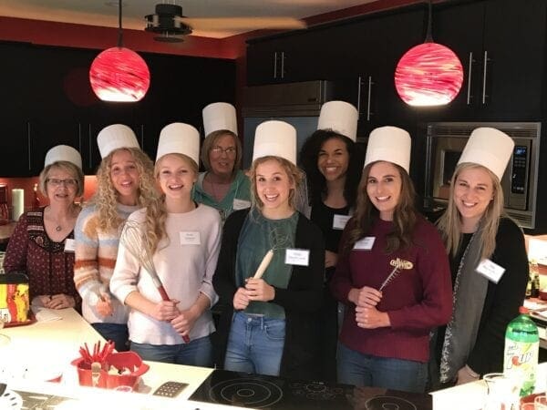 Group of girls wearing white cap cooking