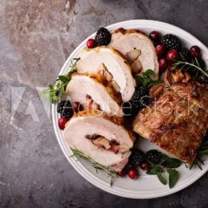 Roasted turkey with cranberries and cranberries on a plate.