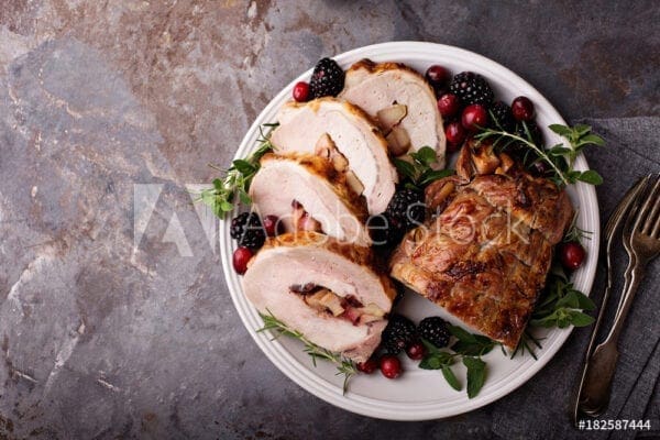 Roasted turkey with cranberries and cranberries on a plate.