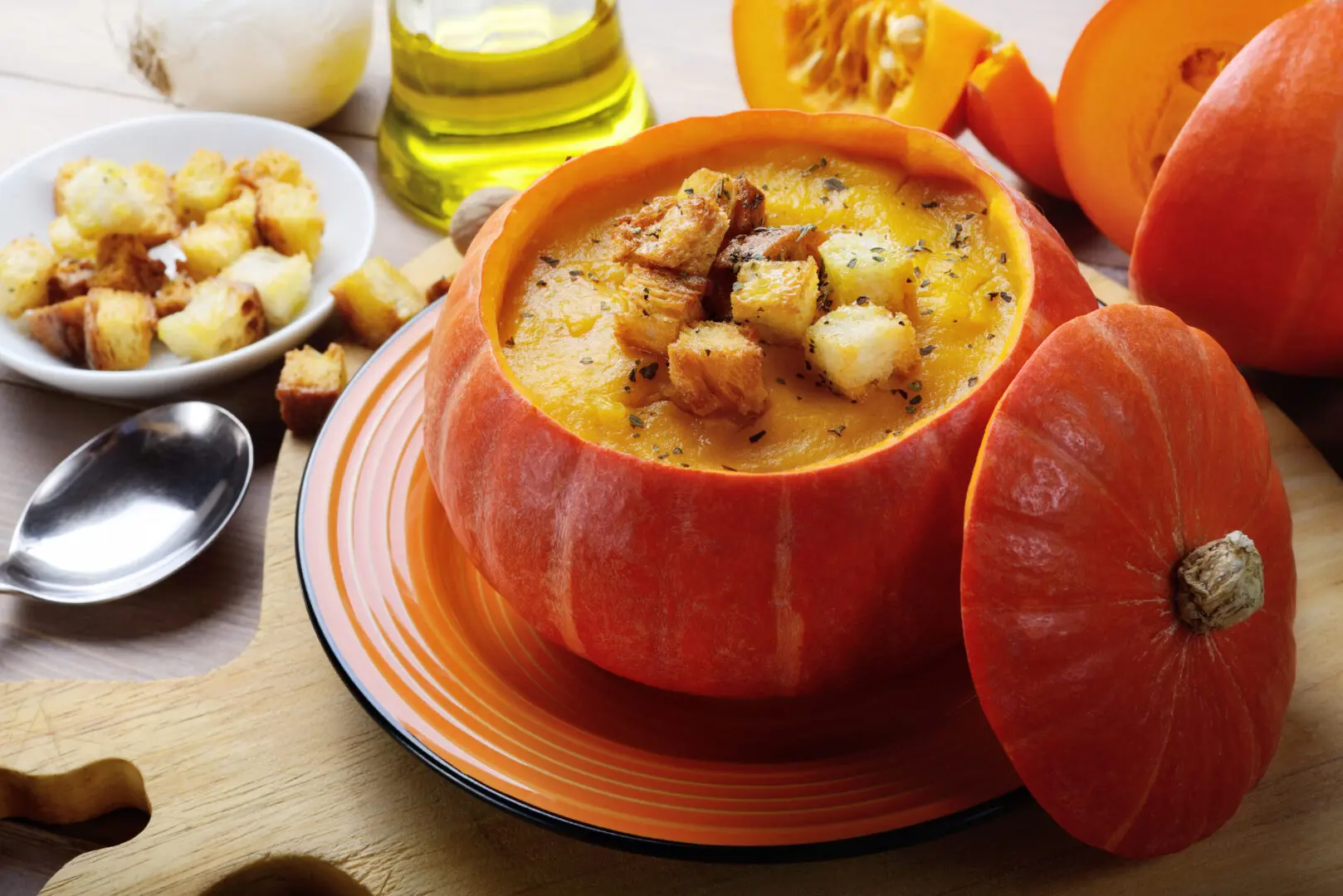 A bowl of soup on a wooden cutting board.