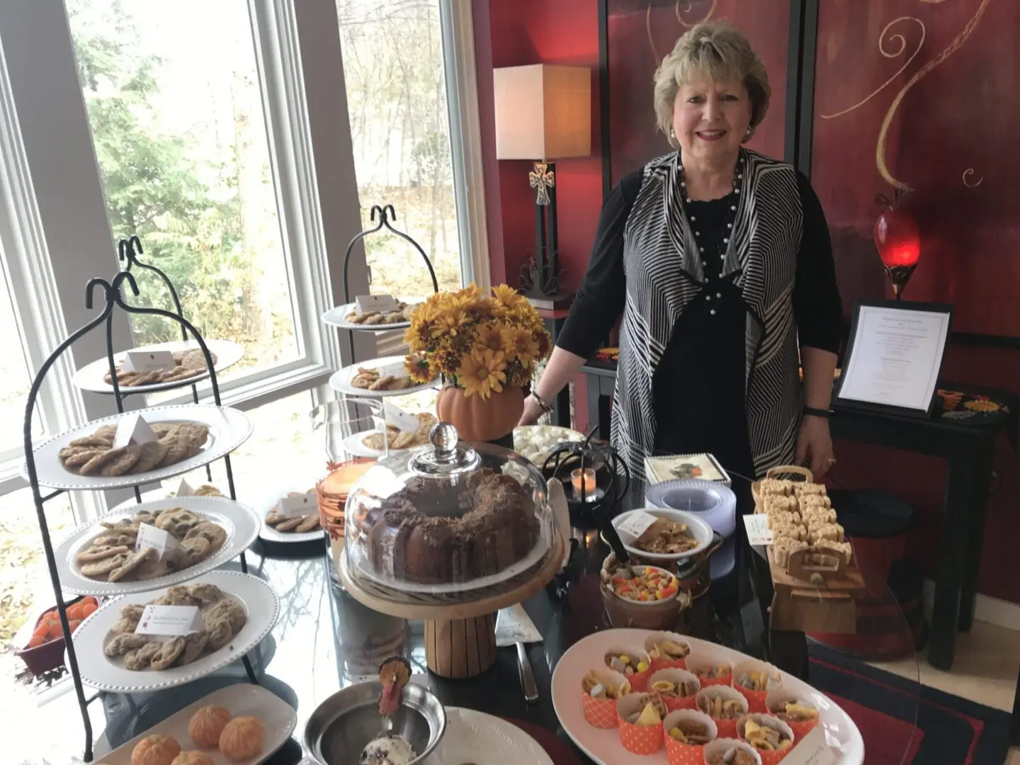 A woman standing in front of a table full of pastries.