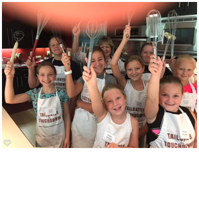 A group of girls in aprons holding up aprons.